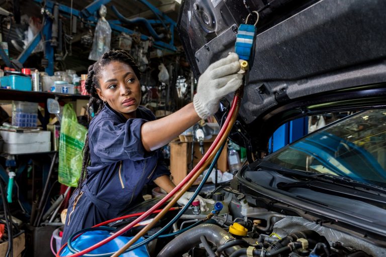 Auto mechanic monitor to check and fixed car air conditioner system in car garage.